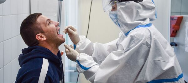 Сотрудник медицинской службы аэропорта Шереметьево проводит экспресс-тестирование на COVID-19 для пассажиров системой EMG Сотрудник медицинской службы аэропорта Шереметьево проводит экспресс-тестирование на COVID-19 для пассажиров системой EMG - Sputnik Latvija