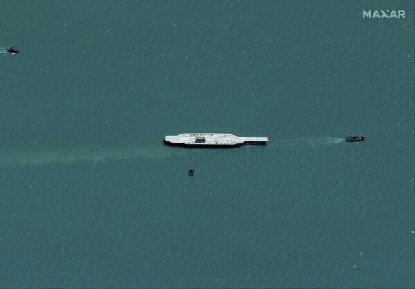 ASV aviācijas bāzes kuģa makets aiz velkoņa Irānas militārajās mācībās Ormuza šaurumā - Sputnik Latvija
