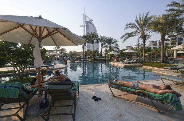 Tūristi sauļojas pie Al Naseem viesnīcas baseina Dubaijā, Apvienotajos Arābu Emirātos.  - Sputnik Latvija