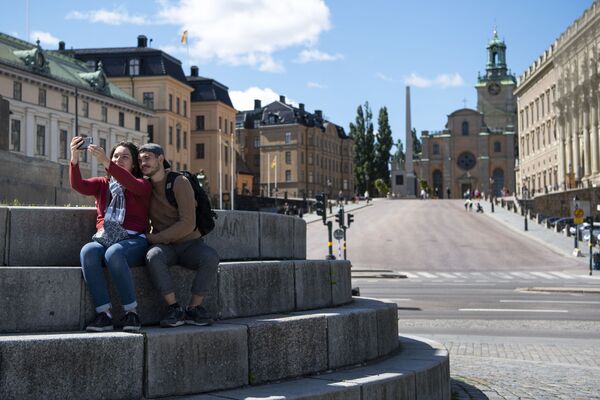 Jaunieši taisa pašfoto pie Karaliskās pils Stokholmas centrā, Zviedrijā. - Sputnik Latvija