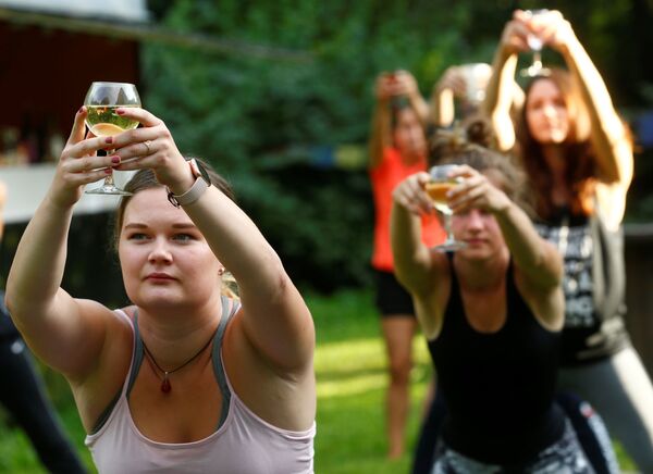 Люди с бокалами вина во время йоги в Латвии  - Sputnik Латвия