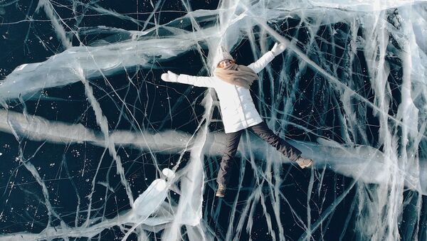 Девушка лежит на льду замерзшего Байкала - Sputnik Латвия