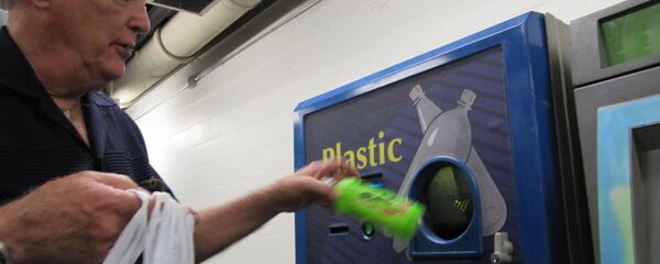 Мужчина возле аппарата по приёму бутылок - Sputnik Латвия