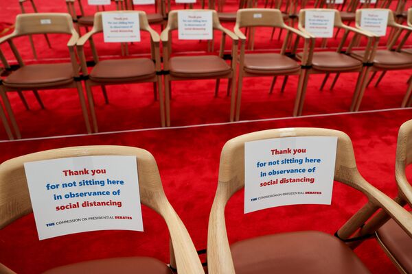 Пустые стулья с призывом соблюдать социальную дистанцию в помещении, где проходили первые дебаты Дональда Трампа и Джо Байдена - Sputnik Латвия