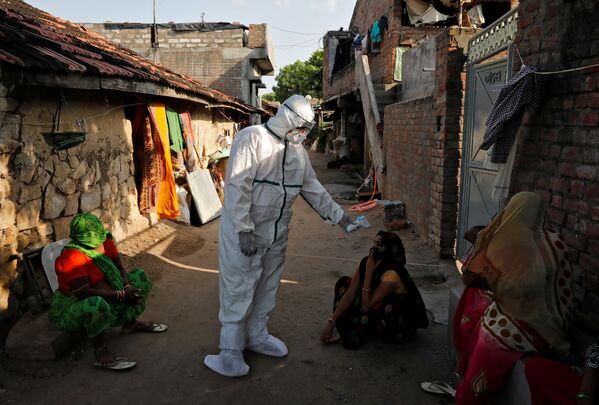 Темпы распространения коронавируса в Индии так растут, что скоро эта страна может выйти на первое место в мире по количеству зараженных. На фото - медицинские работники  проводят термоскрининг жителей бедных районов Индии - Sputnik Латвия