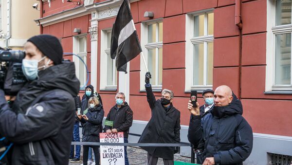 Протестующий поднимает флаг Латвии в траурной расцветке - Sputnik Латвия