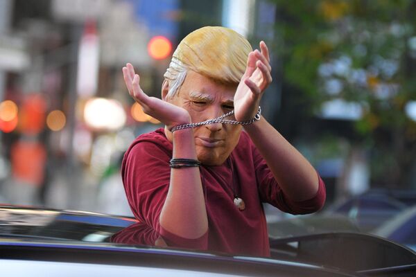 Человек в маске Дональда Трампа едет на машине по улице Нью-Йорка после новостей о победе на выборах президента США кандидата от Демократической партии Джозефа Байдена - Sputnik Латвия