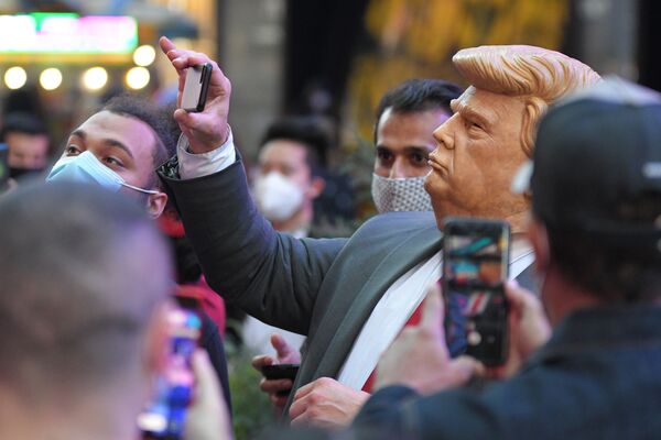 Люди на Таймс-сквер в Нью-Йорке фотографируют человека в маске Дональда Трампа - Sputnik Латвия