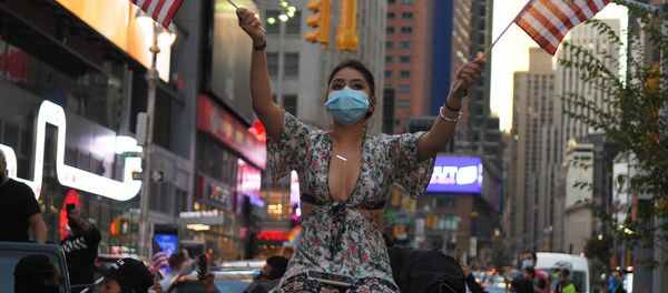 Девушка на одной из улиц в Нью-Йорке после новостей о победе на выборах президента США кандидата от Демократической партии Джозефа Байдена Девушка на одной из улиц в Нью-Йорке после новостей о победе на выборах президента США кандидата от Демократической партии Джозефа Байдена - Sputnik Latvija