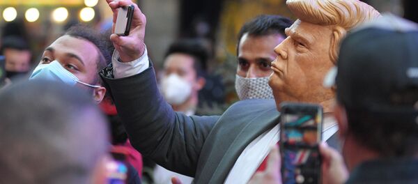 Люди на Таймс-сквер в Нью-Йорке фотографируют человека в маске Дональда Трампа Люди на Таймс-сквер в Нью-Йорке фотографируют человека в маске Дональда Трампа - Sputnik Латвия
