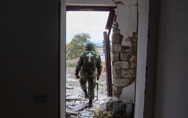 Karavīrs pie apšaudes rezultātā bojātās mājas Stepanakertā - Sputnik Latvija