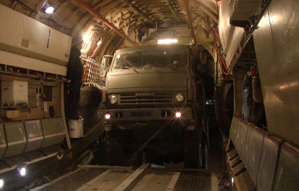 Kara tehnikas iekraušana un personālsastāva sēšanās smagajās kara transporta lidmašīnās Il-76 Uļjanovsk-Vostočnij aerodromā - Sputnik Latvija