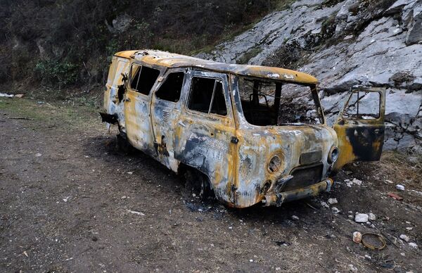 Автомобиль, поврежденный в результате обстрелов, на обочине дороги в Нагорном Карабахе - Sputnik Латвия