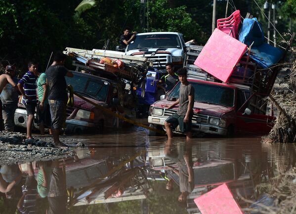 Рабочие на затопленной дороге во время эвакуации в связи с надвигающимся ураганом Йота в Эль-Прогресо, Гондурас - Sputnik Латвия