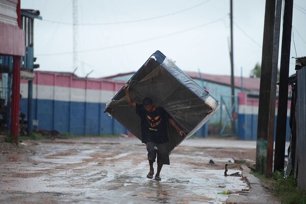 Мужчина с матрасом на одной из улиц Пуэрто-Кабесас в Никарагуа направляется в убежище, спасаясь от надвигающегося урагана Йота - Sputnik Латвия