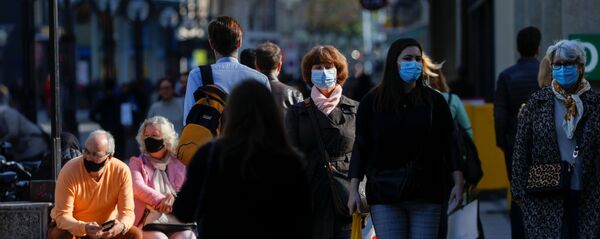 Люди в защитных масках на улице Женевы Люди в защитных масках на улице Женевы - Sputnik Latvija