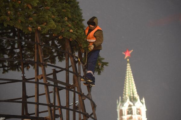 Strādnieks uzstāda Jaungada egli Sarkanajā laukumā, Maskavā. - Sputnik Latvija