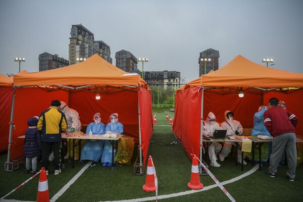 Жители проходят тесты на COVID-19 во временном центре тестирования в Тяньцзине, Китай - Sputnik Латвия