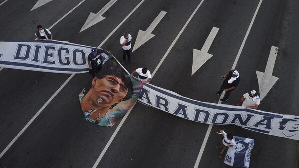 Болельщики с баннером во время скорби по Диего Марадоне в Аргентине  - Sputnik Latvija