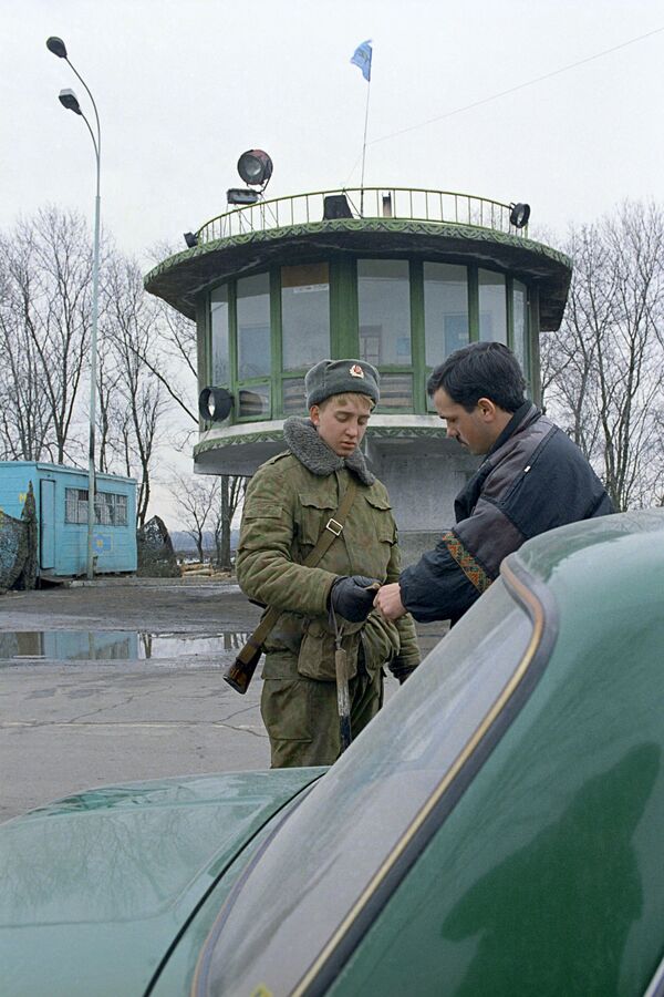 Солдат российских миротворческих сил проверяет автотранспорт на въезде в город Бендеры во время конфликтов в Приднестровье. - Sputnik Latvija