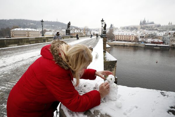Женщина лепит снеговика на Карловом мосту в Праге, Чехия - Sputnik Латвия