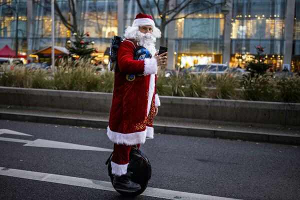 Человек в костюме Санта-Клауса участвует в берлинском шествии на моноколесе - Sputnik Латвия