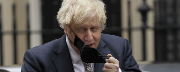 Премьер-министр Великобритании Борис Джонсон снимает маску - Sputnik Латвия