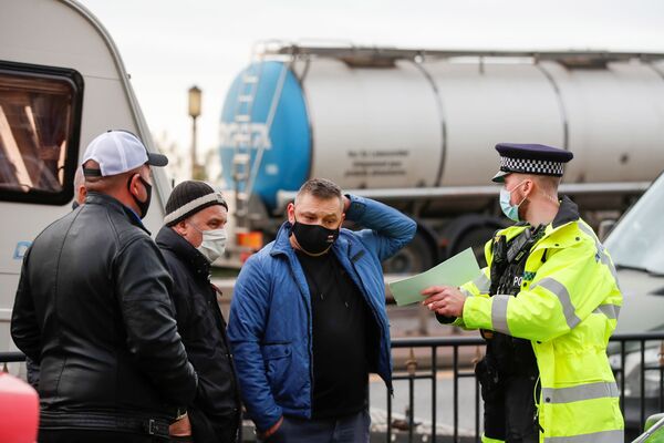 Полицейский разговаривает с польскими водителями возле порта Дувра и перенаправляет их в аэропорт Манстон - Sputnik Латвия