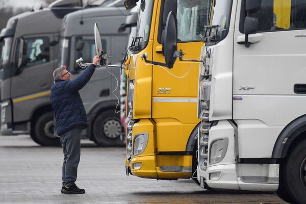 Венгерский дальнобойщик во время установки антенны на свой грузовик в Великобритании  - Sputnik Латвия
