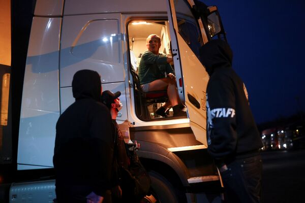 Чешский водитель разговаривает с коллегами, сидя в своем грузовике, на международной стоянке грузовиков в Эшфорде - Sputnik Латвия
