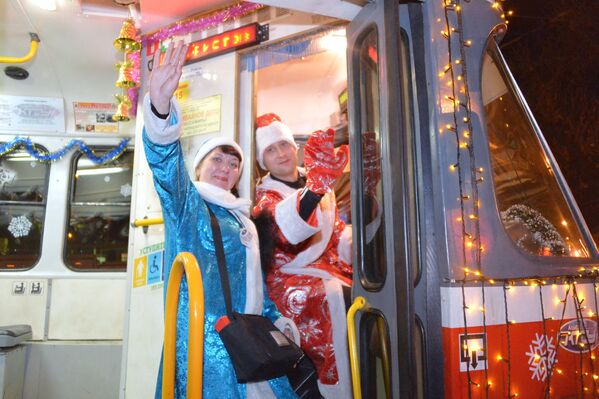 Водитель в костюме Деда Мороза и кондуктор в костюме Снегурочки в новогоднем трамвае в Краснодаре - Sputnik Latvija