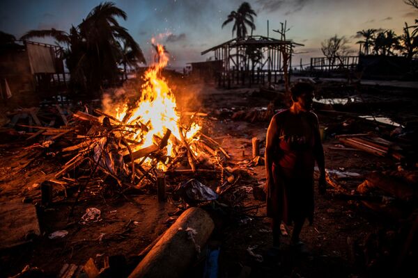 Люди сжигают мусор, оставшийся после урагана Йота в Бильви, Никарагуа - Sputnik Латвия