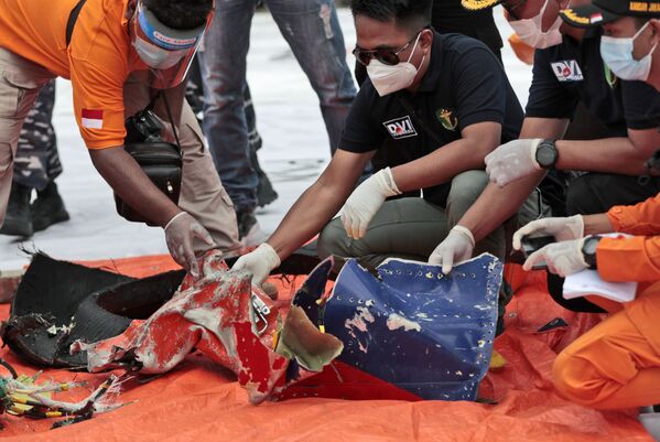 Izmeklētāji aplūko atlūzas, kas atrastas ūdeņos pie Javas salas pēc Sriwijaya Air lidmašīnas katastrofas - Sputnik Latvija
