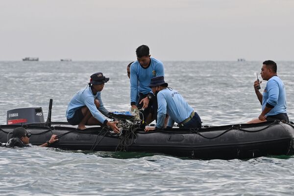 Водолазы ВМС Индонезии собирают обломки рейса Sriwijaya Air SJY182 во время поисково-спасательной операции в море недалеко от острова Ланканг  - Sputnik Латвия
