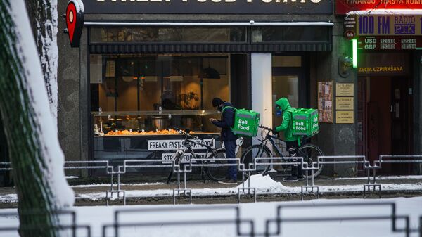 Доставщики еды на велосипедах ожидают готовности заказа - Sputnik Латвия