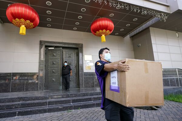 Сотрудник FedEx забирает ящик из китайского консульства в Хьюстоне - Sputnik Латвия