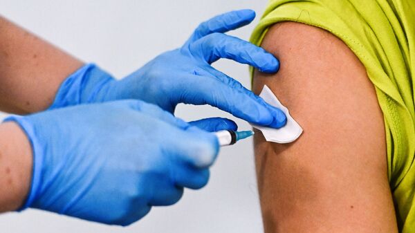 Девушке делают прививку от коронавируса в пункте вакцинации - Sputnik Latvija
