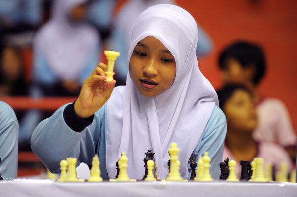 Молодая девушка в хиджабе принимает участие в показательной игре в шахматы в гимназии в Джакарте - Sputnik Латвия