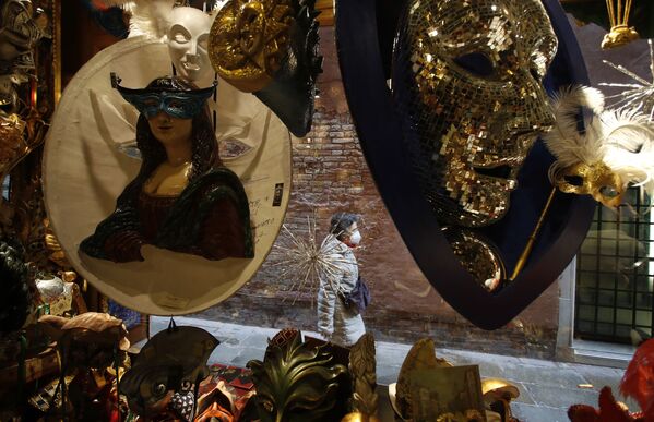Женщина походит мимо витрины с карнавальными масками в Венеции  - Sputnik Латвия