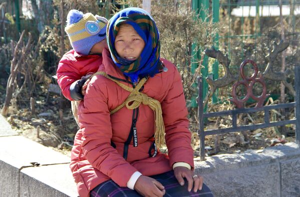 Женщина с ребенком на одной из улиц города Лхаса в Тибете - Sputnik Латвия