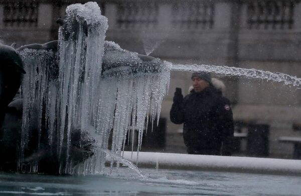 Мужчина фотографирует покрытую льдом статую на Трафальгарской площади в Лондоне - Sputnik Латвия
