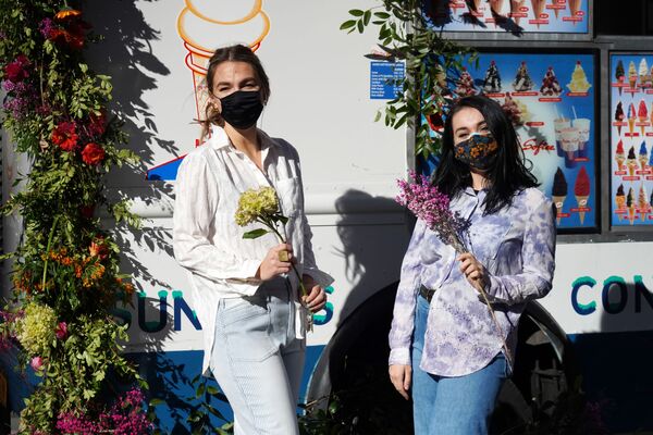 Девушки с букетами на Рокфеллер Плаза в преддверии Дня святого Валентина в Нью-Йорке, США - Sputnik Латвия