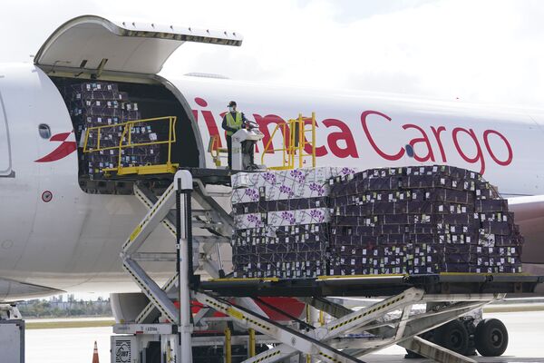 Разгрузка самолета Airbus A330-200F с грузом цветов в преддверии Дня святого Валентина на складе в международном аэропорту Майами, США - Sputnik Латвия