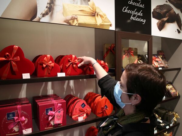 Продавец одного из самых престижных производителей шоколада Бельгии расставляет коробки во время подготовки ко Дню святого Валентина в Брюсселе, Бельгия - Sputnik Латвия