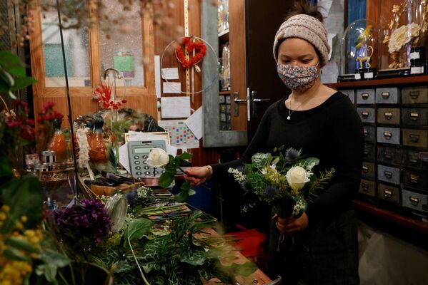 Цветочница в защитной маске собирает букет в цветочном магазине перед Днем святого Валентина в Париже, Франция - Sputnik Латвия