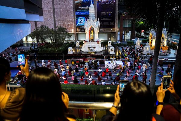 Люди молятся во время религиозной церемонии в храме Пхра Тримурти, Богу любви, чтобы пожелать удачи в поисках родственных душ в преддверии Дня святого Валентина в торговом районе Бангкока, Таиланд - Sputnik Latvija