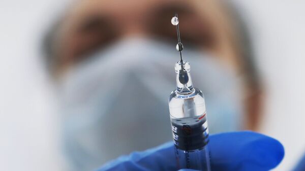 Медик готовит шприц с вакциной - Sputnik Латвия