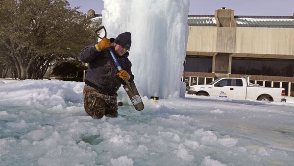 Рабочий ломает лед в замерзшем фонтане в Ричардсоне, штат Техас, США - Sputnik Латвия