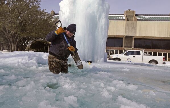 Рабочий ломает лед в замерзшем фонтане в Ричардсоне, штат Техас - Sputnik Латвия