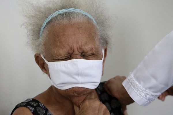 90-летняя Жюстина Батиста во время вакцинации против COVID-19 китайской вакциной Sinovac в Бразилиа, Бразилия - Sputnik Latvija